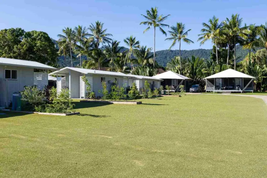 A tropical resort with small white cabins and tent like structures sur