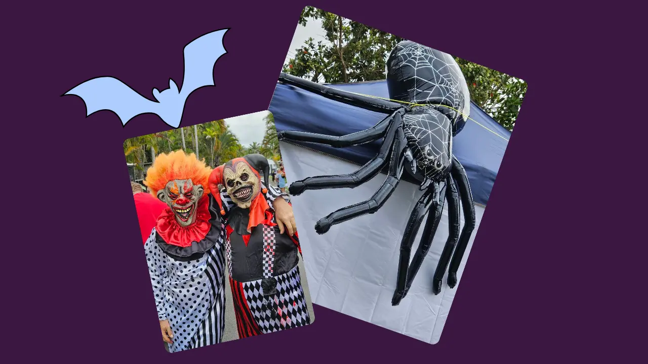 Two costumed figures in clown outfits stand together, a large black spider balloon sculpture hangs on a tent behind them, and a cartoon bat decorates the dark purple background.