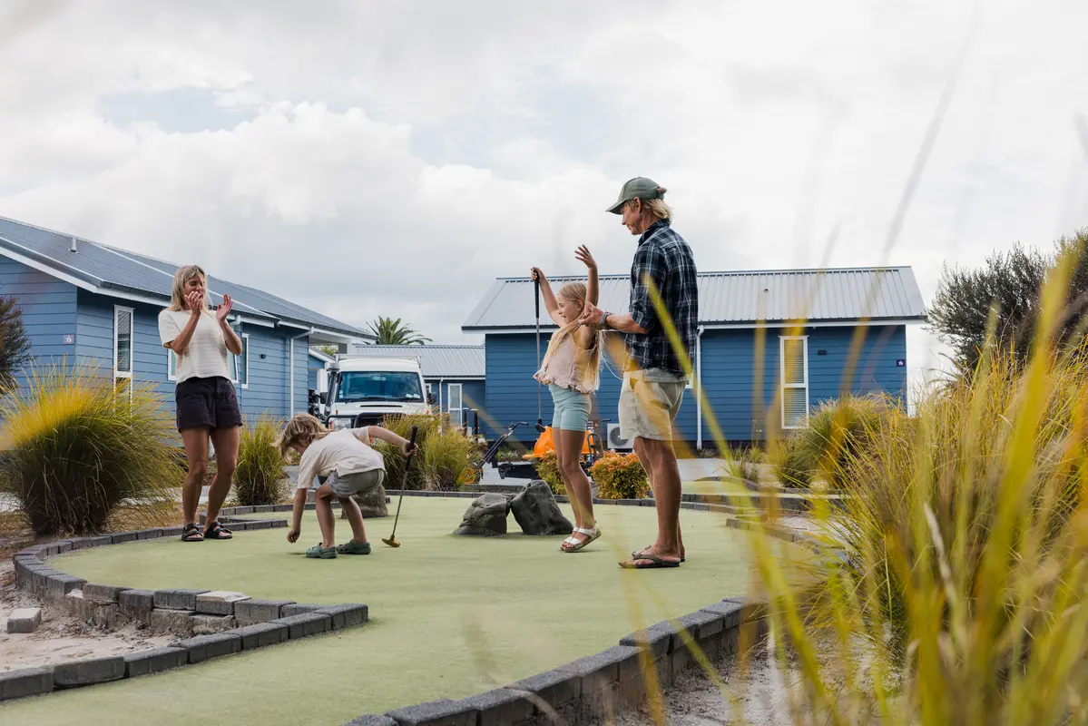 Kids and parents playing mini golf